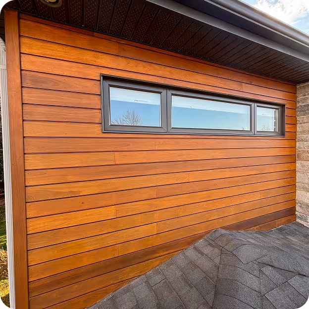 Mur extérieur en bois avec un volet horizontal noir et trois sections vitrées rectangulaires.