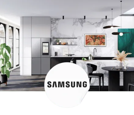 Cuisine moderne avec réfrigérateur Samsung, îlot central en marbre, chaises noires, plantes, et décorations murales colorées.