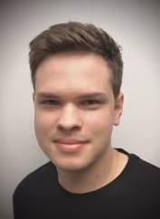 Porträt eines jungen Mannes mit kurzem braunem Haar und schwarzem T-Shirt vor weißem Hintergrund.