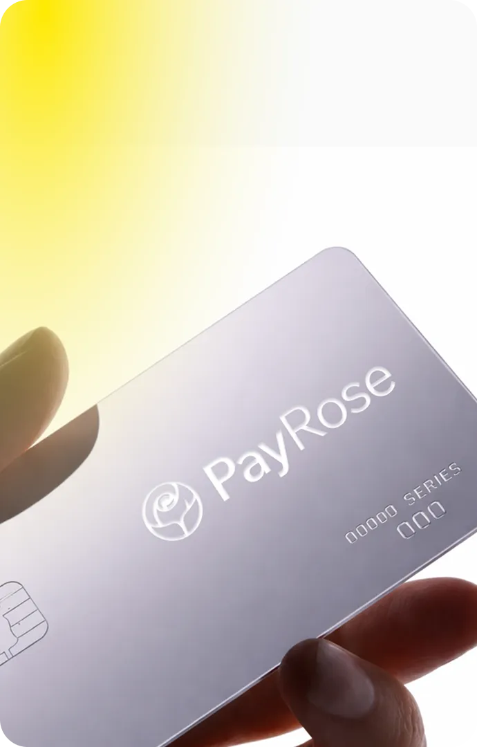 Hand holding a translucent PayRose card with a rose logo and chip, against a bright yellow and white background.