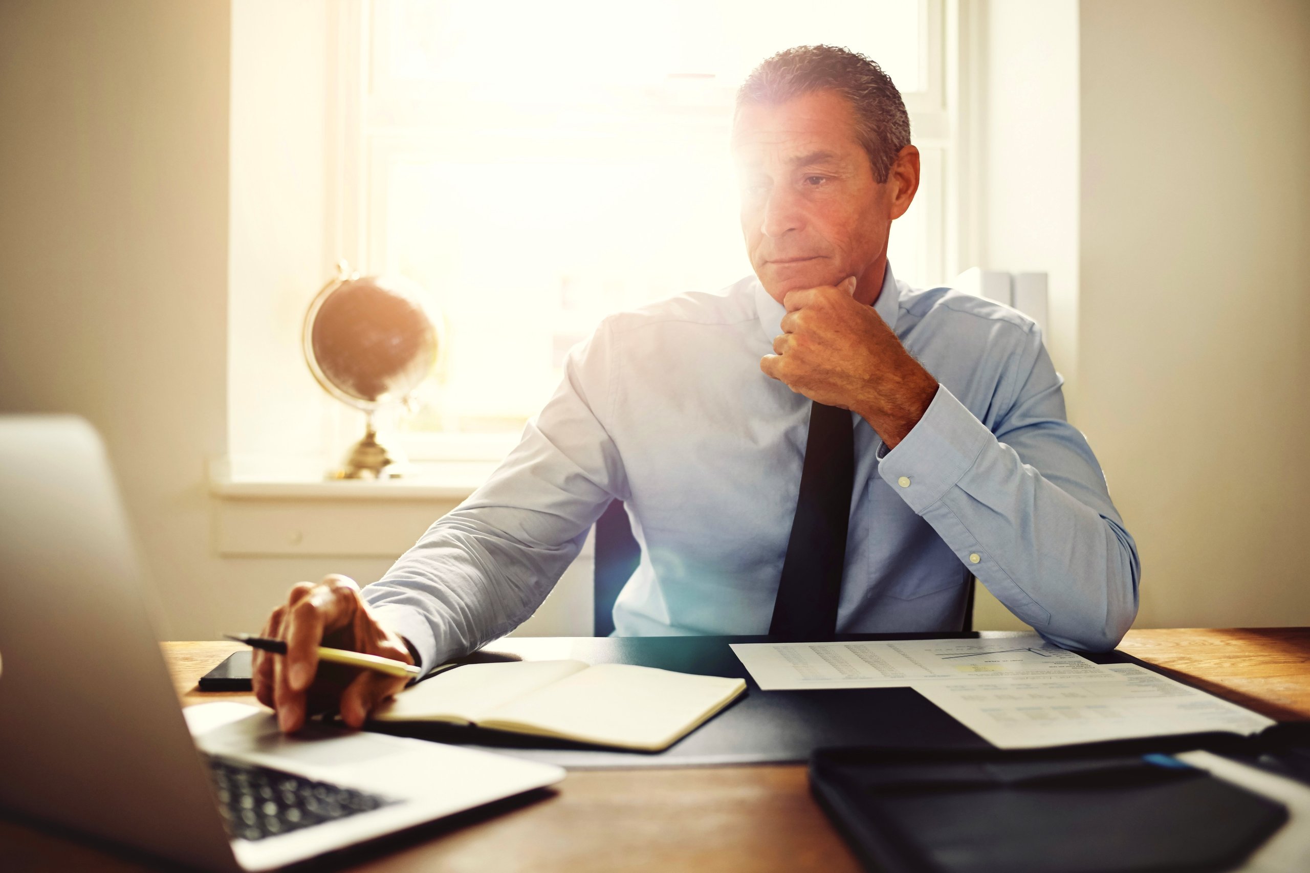 Professional man working on a laptop at a desk.