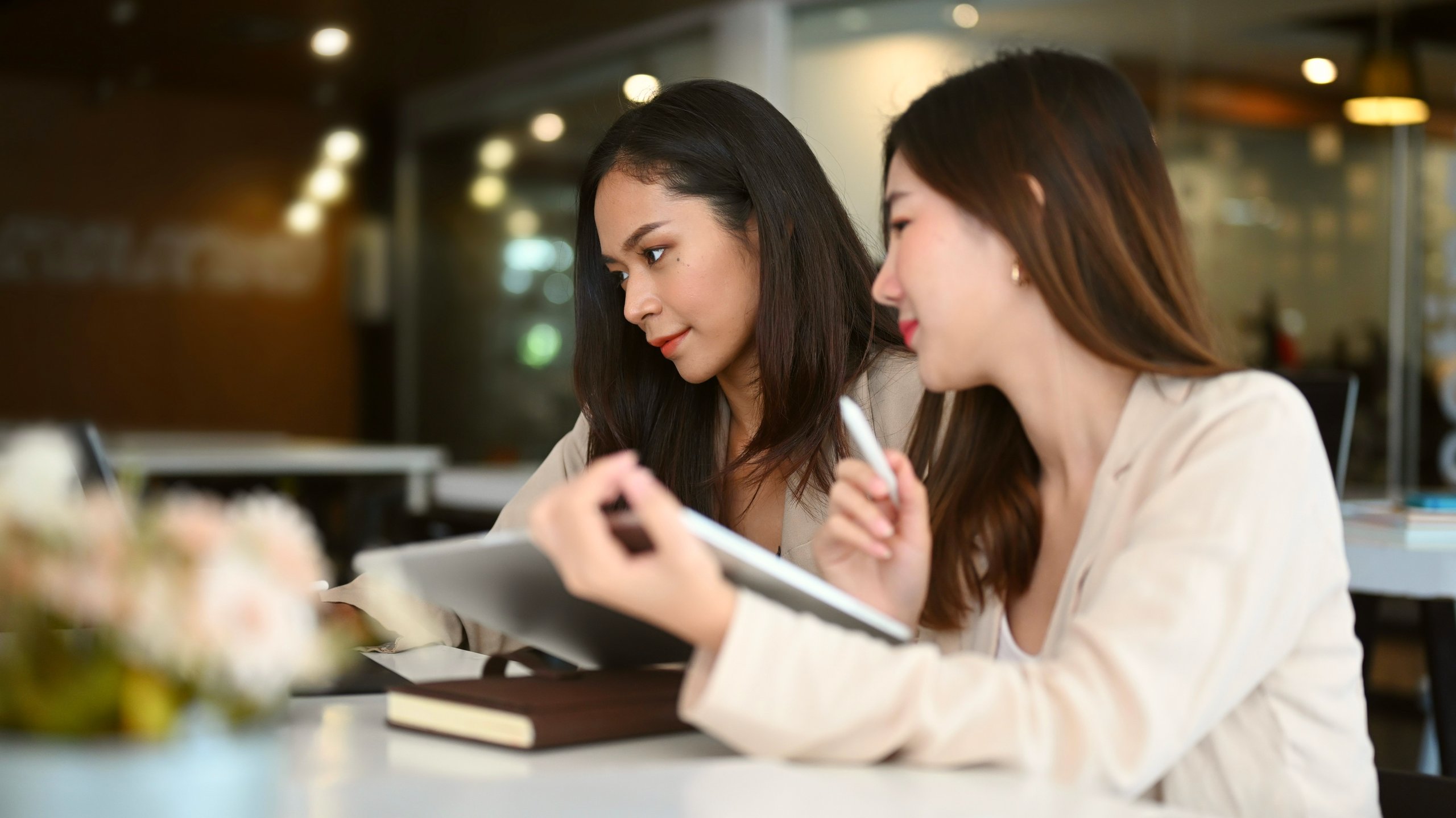 Two women dressed professionally in a meeting.