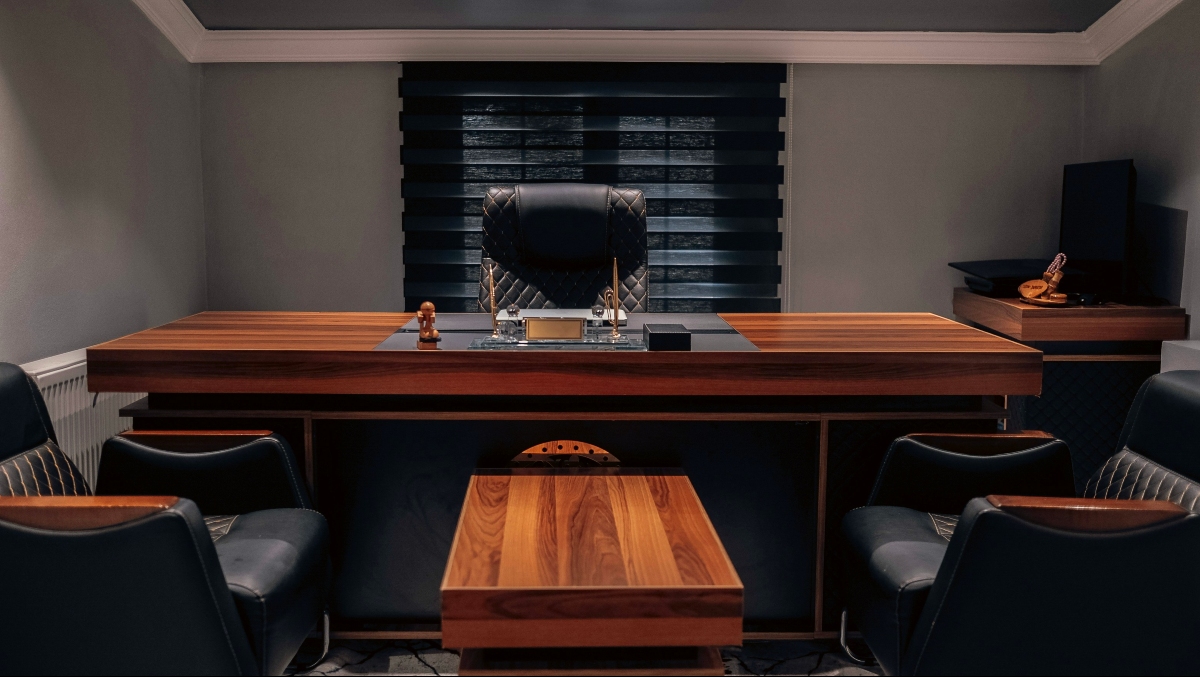 Wood large executive style desk facing outward, with two chairs in front.