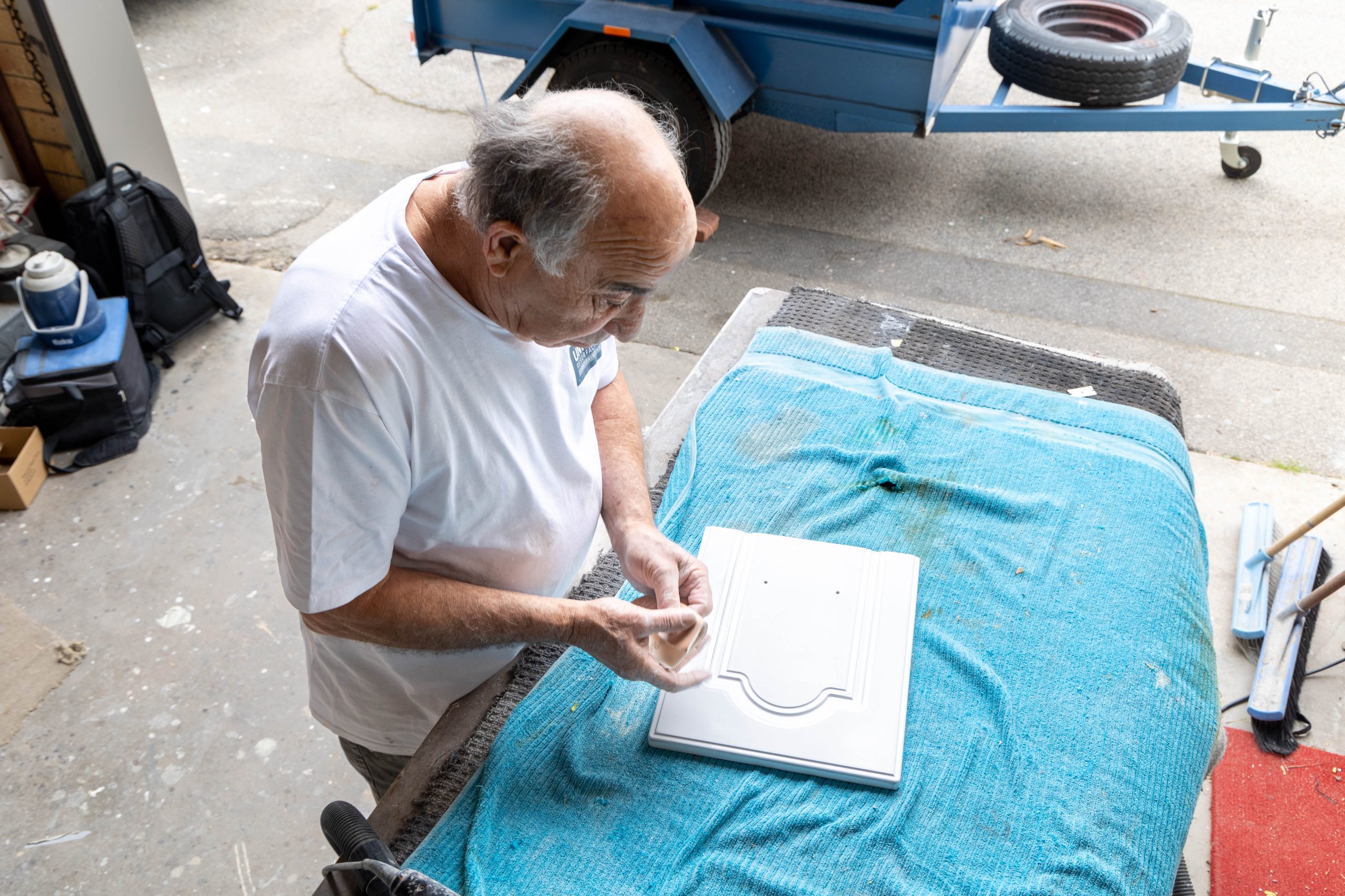 Resurfacing specialist preparing a white cabinet door in the workshop