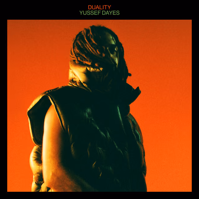 Man with dreadlocks in a black puffer vest against a dark orange background, album title 'Duality' above.