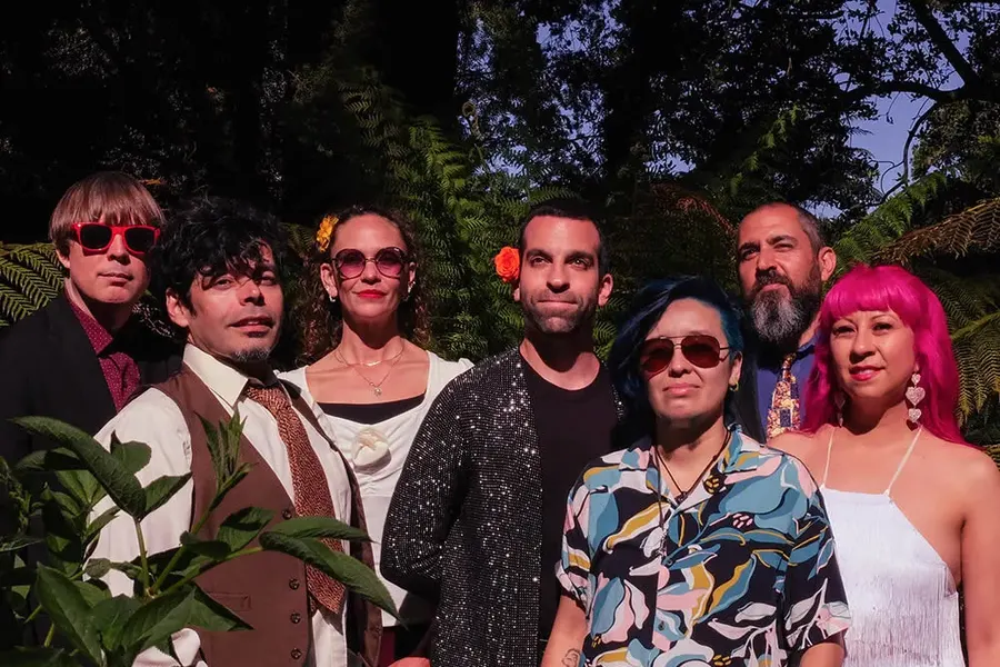Ritmos Tropicosmos band members posing among tropical plants