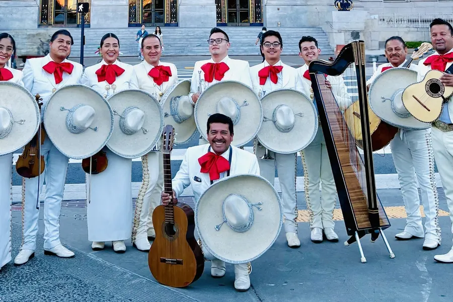 Mariachi San Francisco in white charro suits holding sombreros and instruments