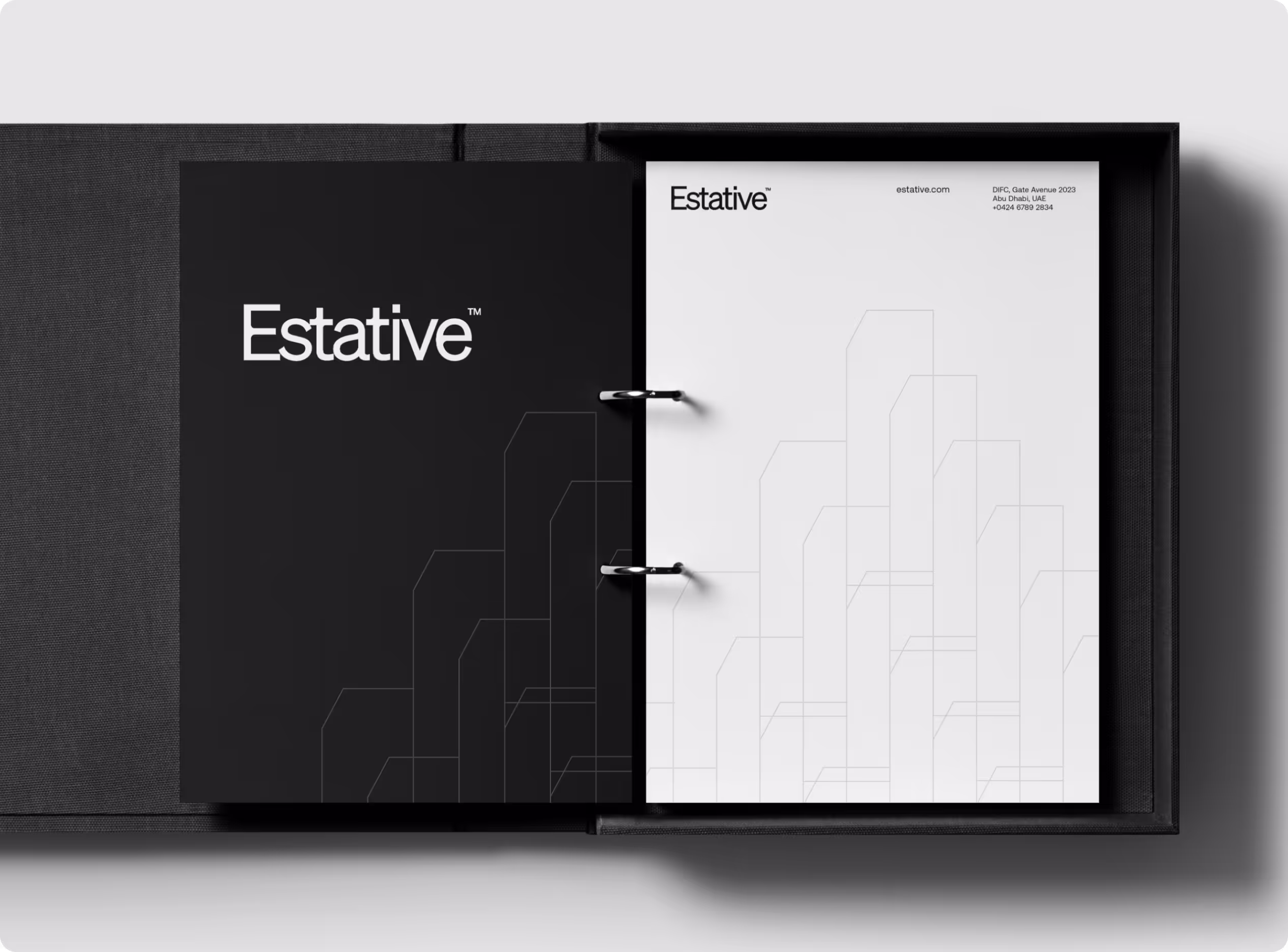 An open black ring binder for Estative, showing a black divider page and a white letterhead, both featuring the brand's geometric skyline line-art pattern. 