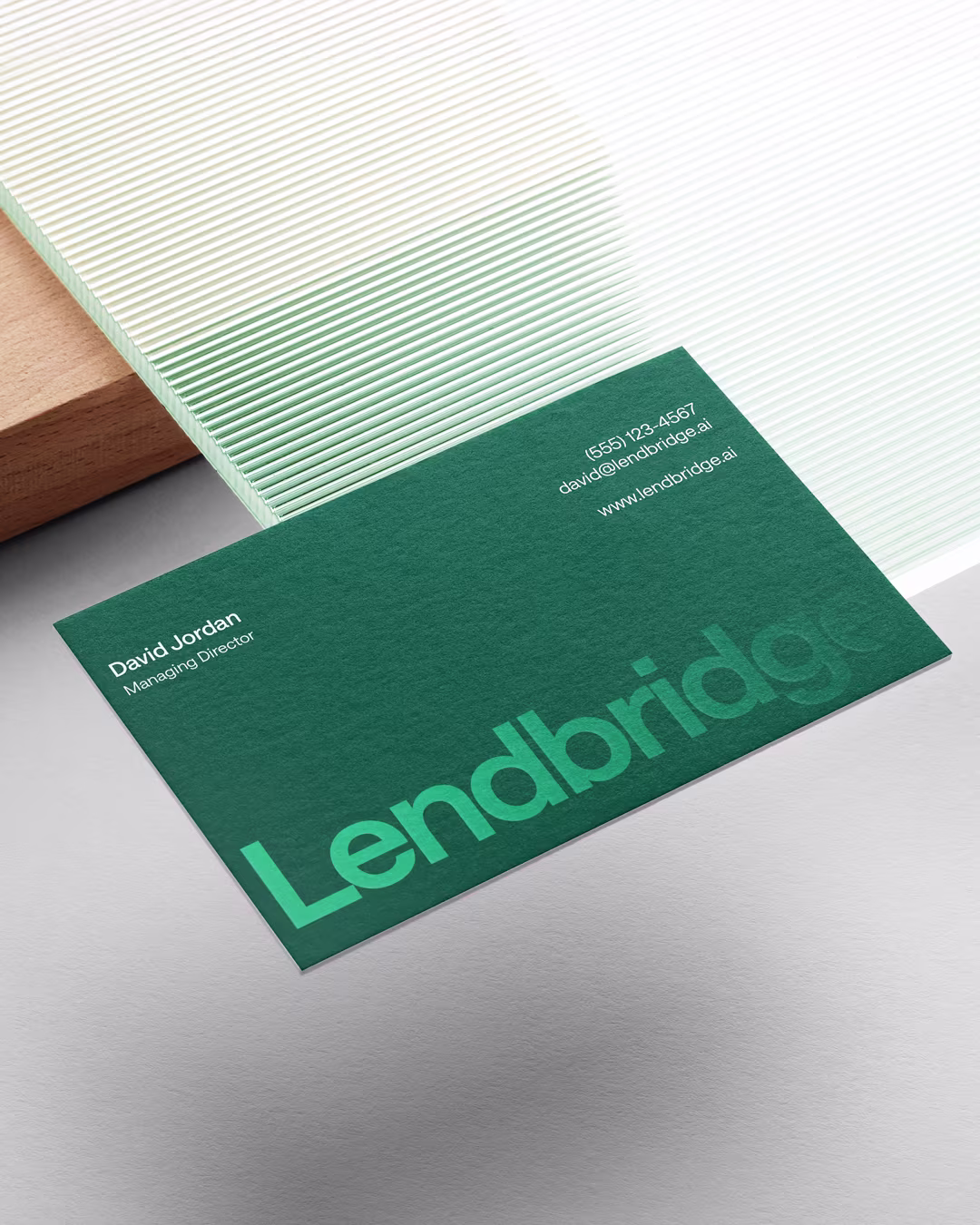A dark green Lendbridge business card for Managing Director David Jordan, set against a background of white fluted glass.