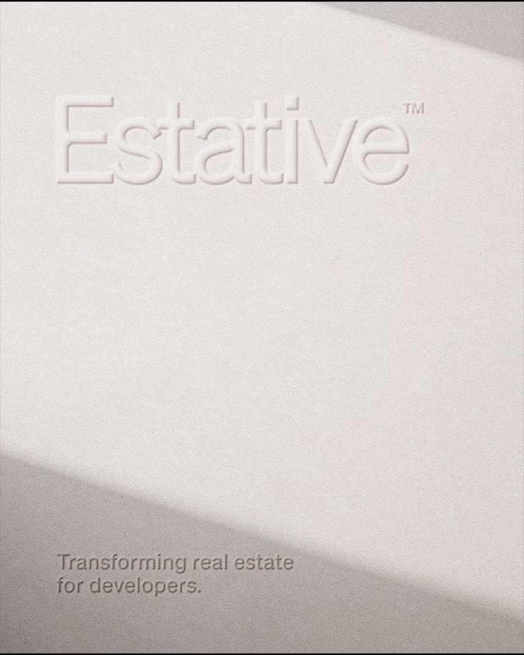 A close-up of a textured white Estative card with an embossed logo and the tagline "Transforming real estate for developers." 