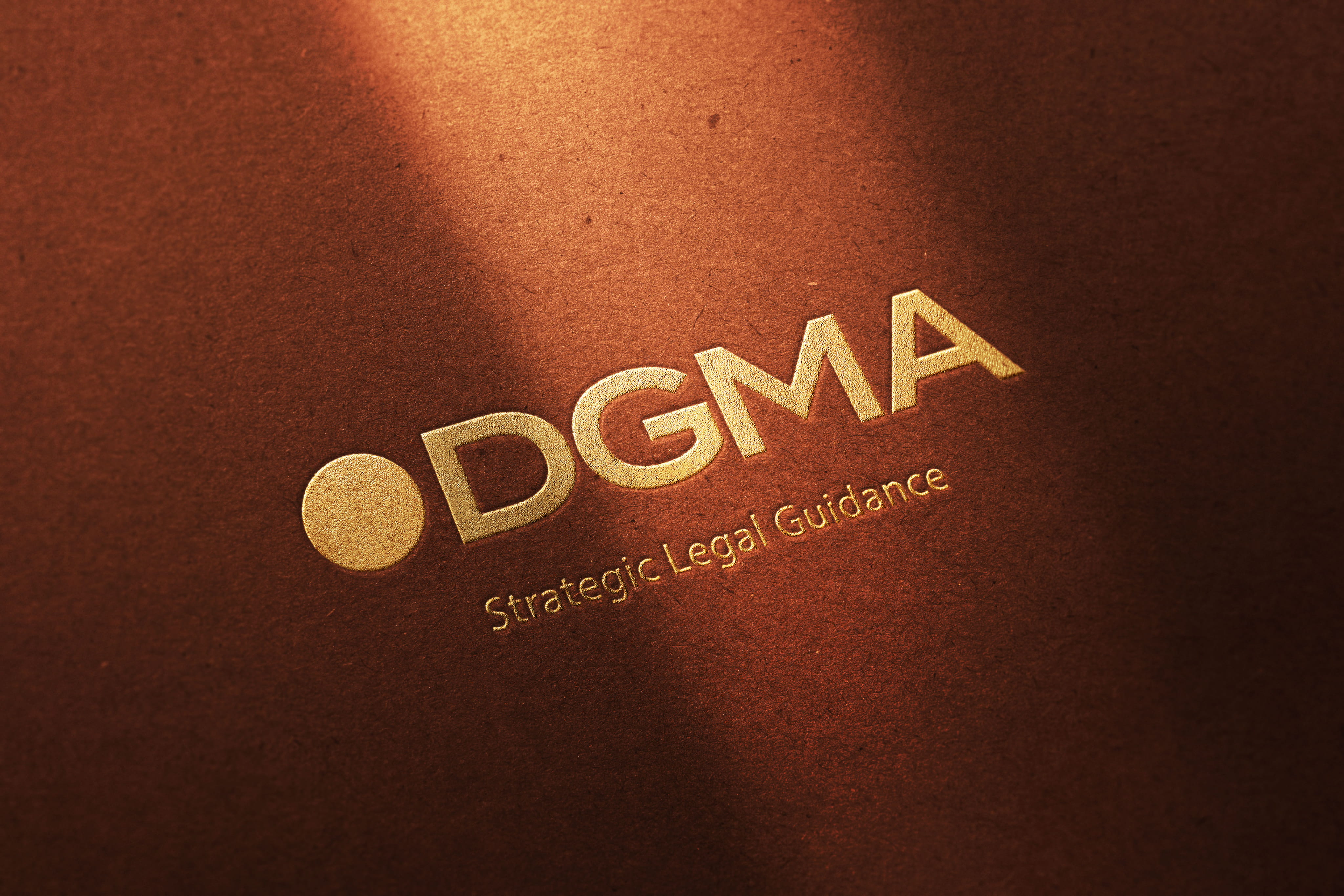 A close-up of a premium DGMA logo embossed in gold foil on a textured, dark copper-toned paper, accompanied by the tagline "Strategic Legal Guidance." 