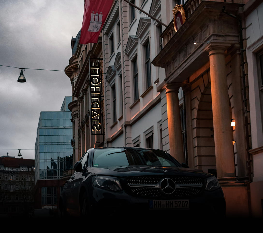 Voiture noire Mercedes de luxe garée devant un bâtiment