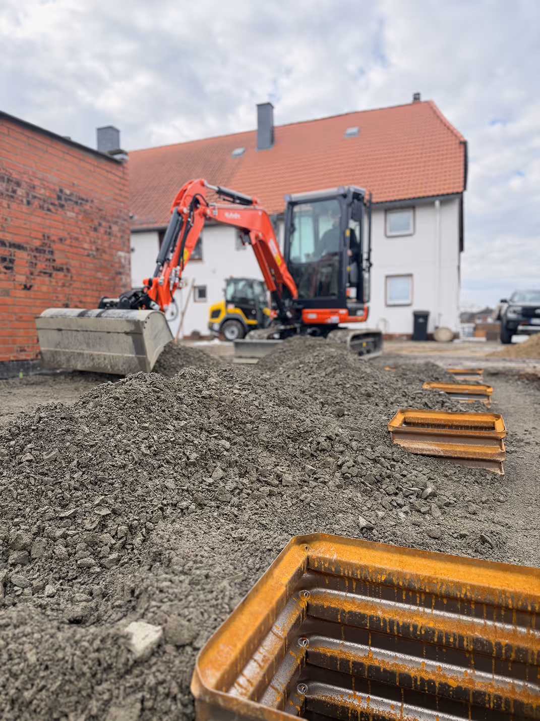 Minibagger bei Erdarbeiten an einem Wohnhaus