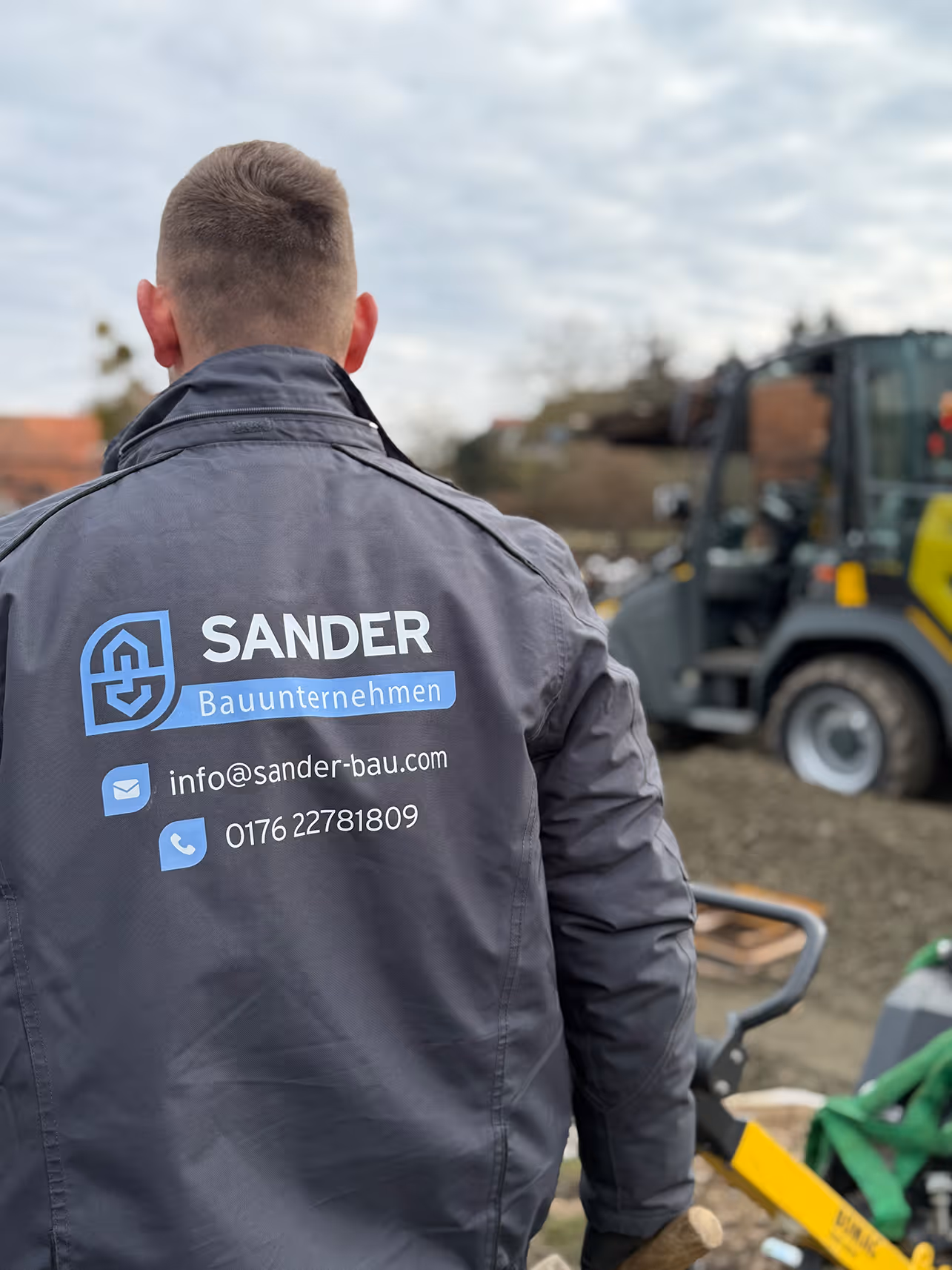 Mitarbeiter der SANDER GmbH in Arbeitsjacke vor einem Radlader