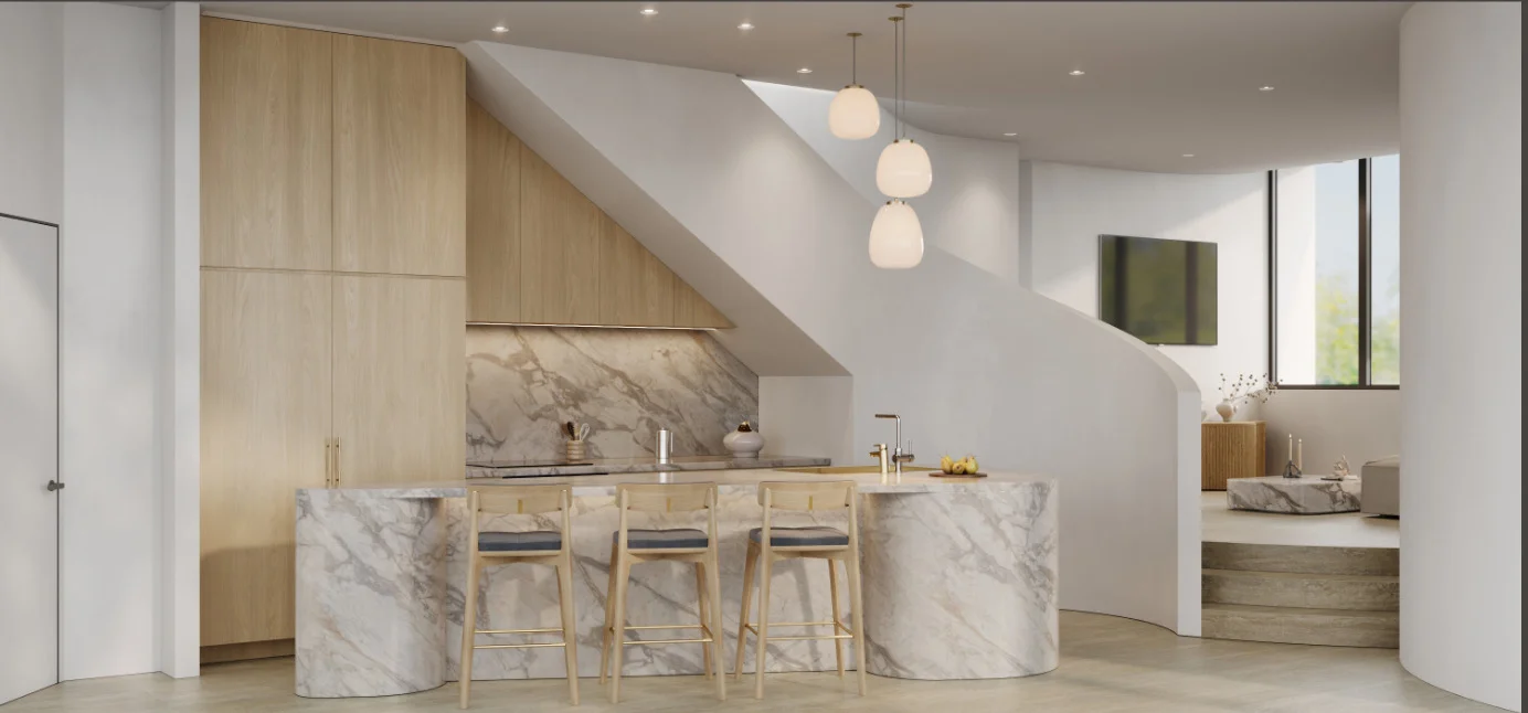 Modern kitchen with marble island and light wood cabinetry under a sloped ceiling, three wooden bar stools with grey cushions, pendant lights, and a curved white staircase leading to a living area.