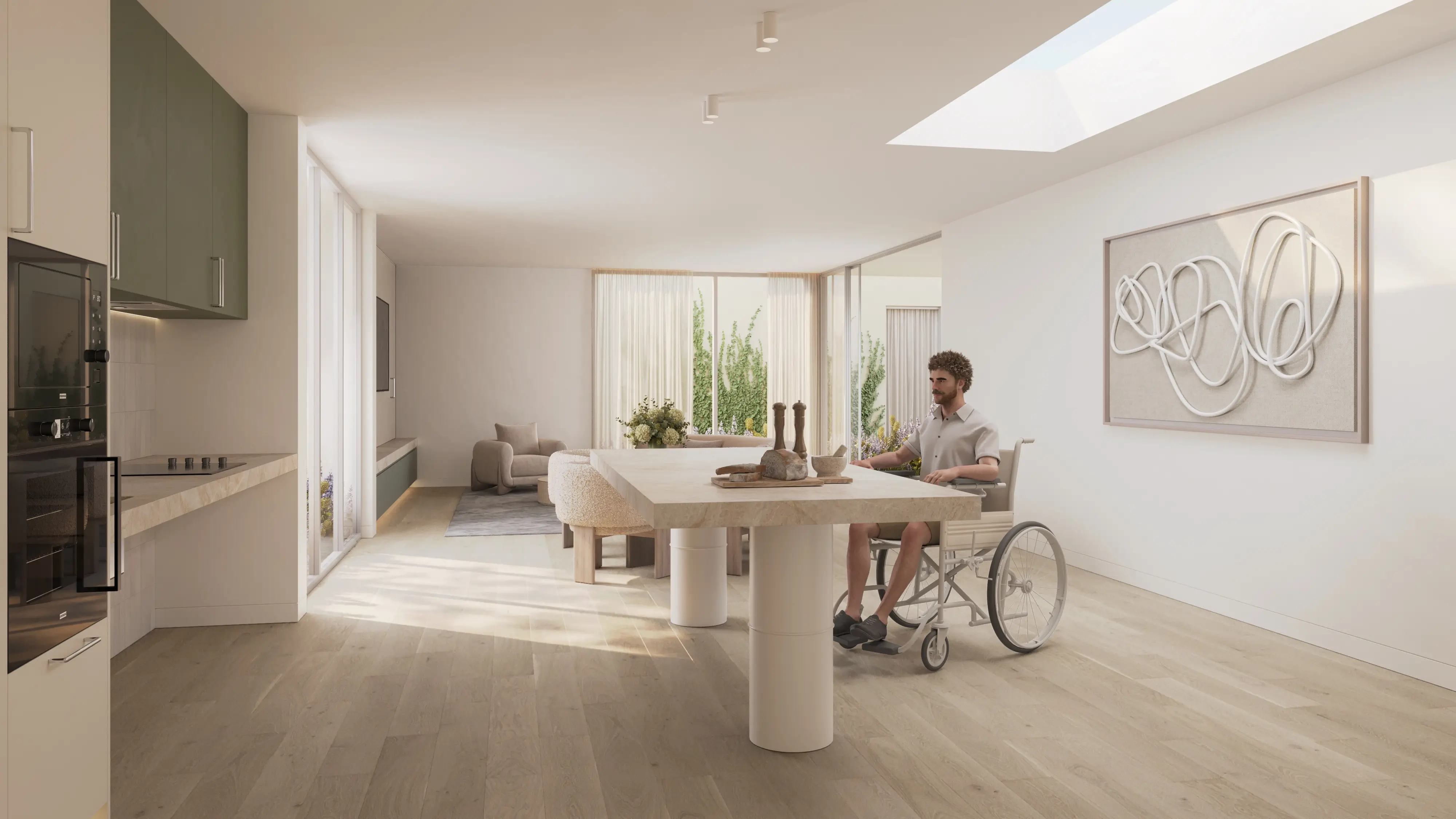 Modern, light-filled kitchen and dining area with a man in a wheelchair sitting at a wooden table, with green cabinets, large windows, and abstract wall art.