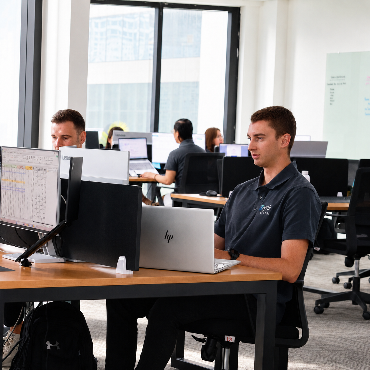 Offshore support team member working at a modern Lynk Global office workstation in Manila.