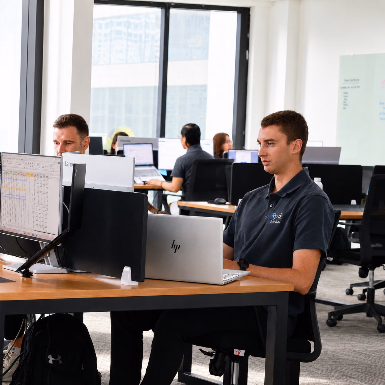 Offshore support team member working at a modern Lynk Global office workstation in Manila.
