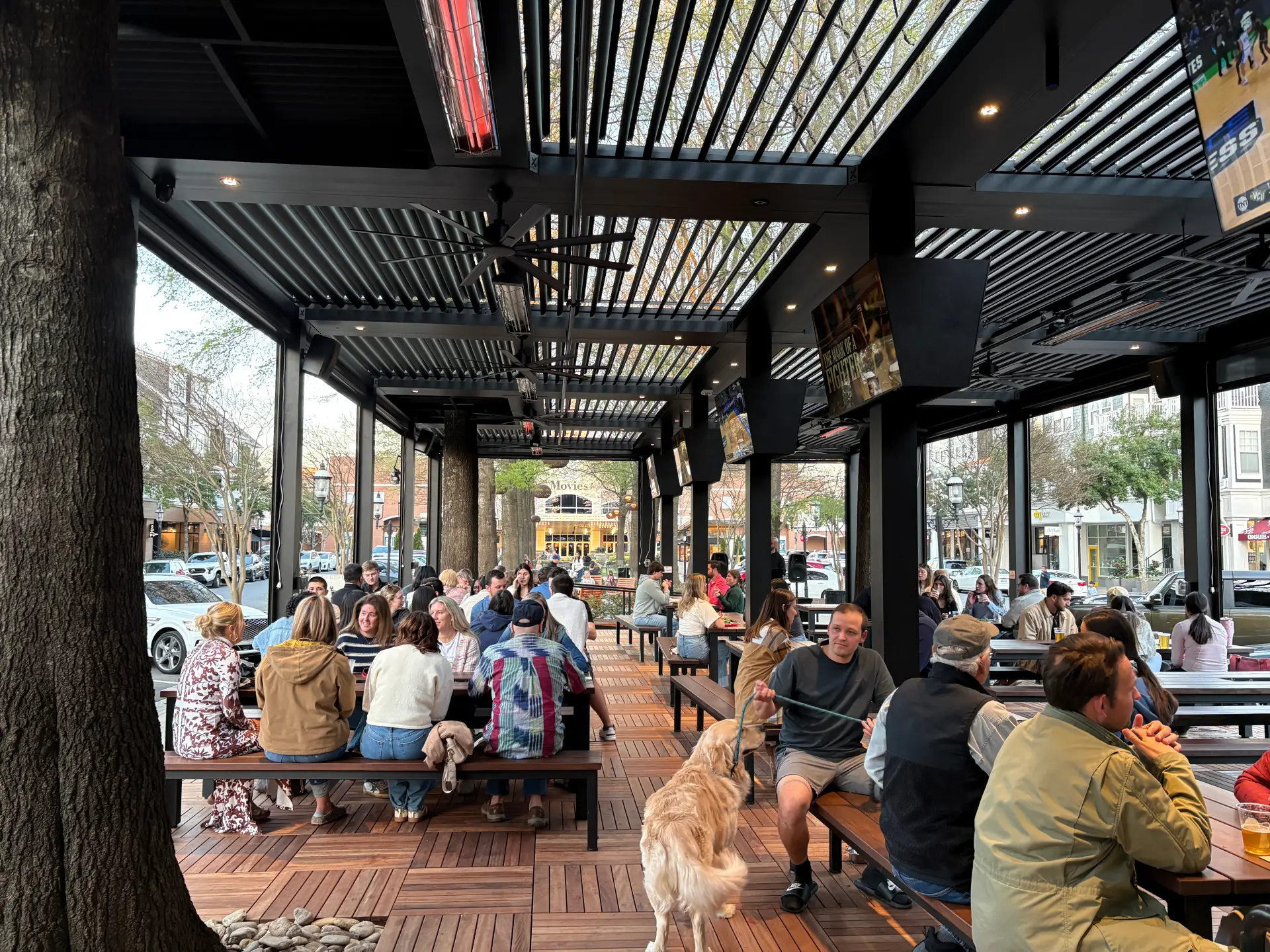 Outdoor covered patio in Huntersville with large groups seated at picnic tables during trivia night