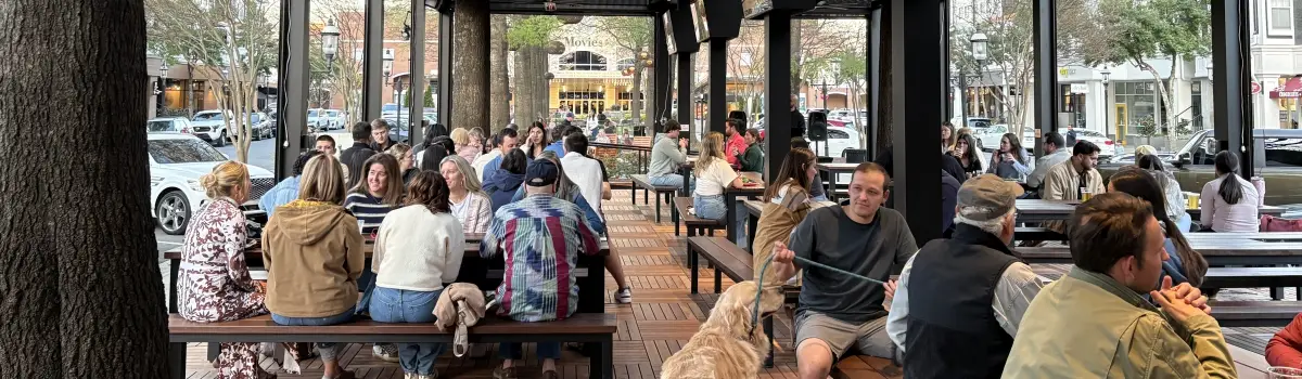 Outdoor covered patio in Huntersville with large groups seated at picnic tables during trivia night