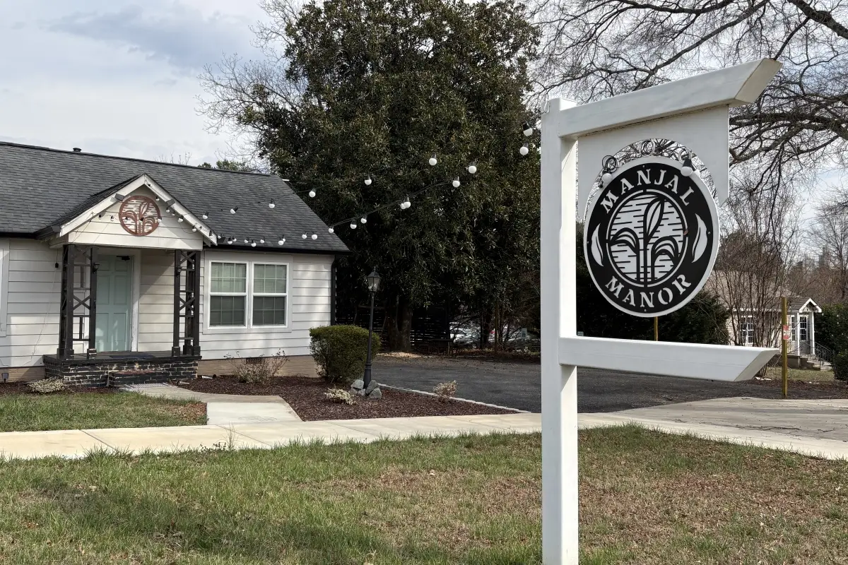 The sign and entrance building for Manjal Manor