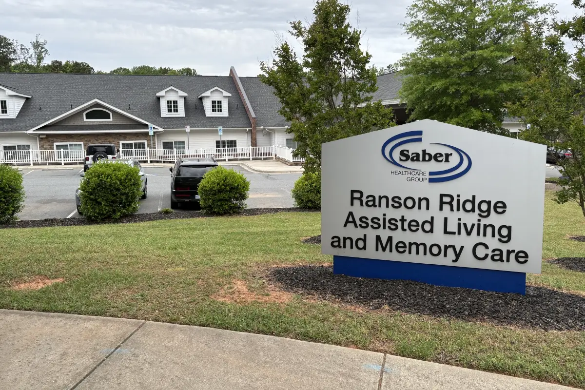 Sign for Ranson Ridge Assisted Living and Memory Care with building exterior in background 