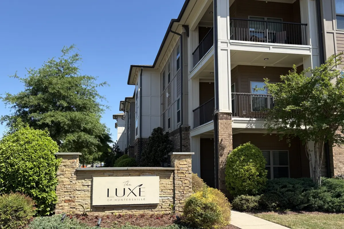The Luxe community sign with residential building exterior in background