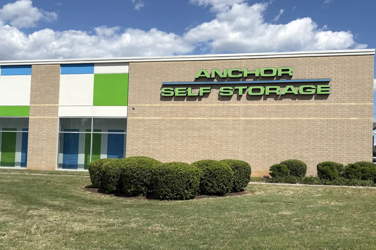 Exterior of Anchor Self Storage building with green signage and landscaped front lawn 