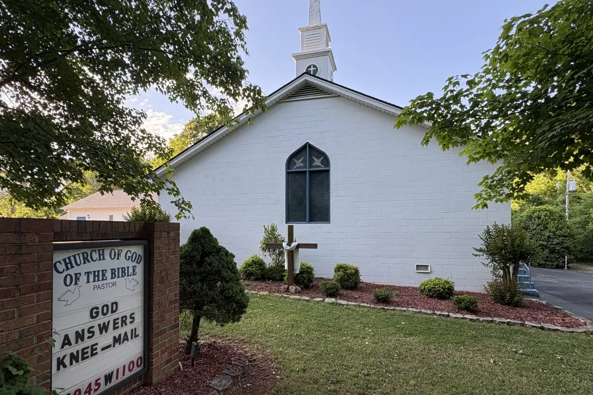 Side of the building of the Church of God and sign with a biblical message