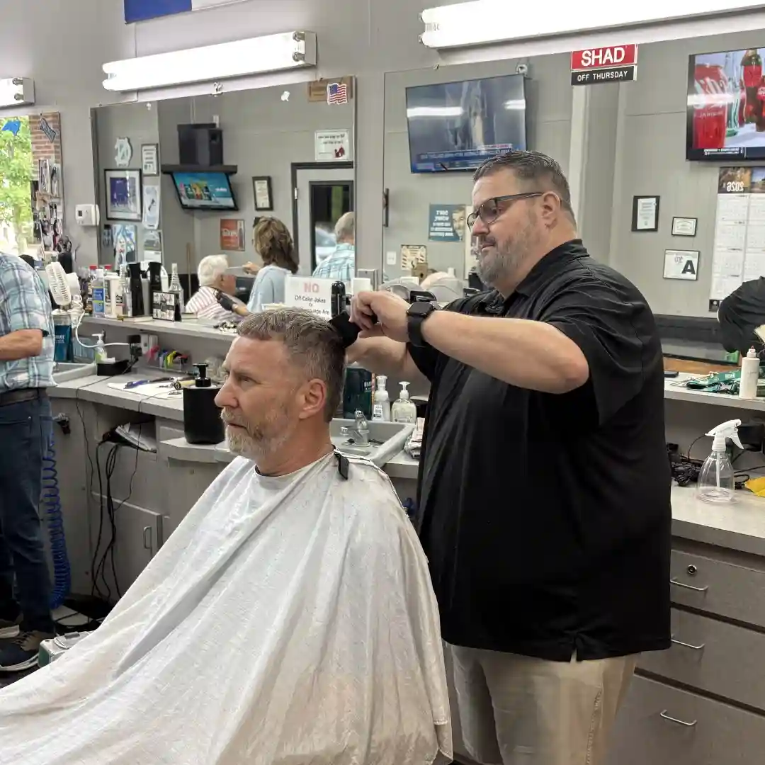 Barber cutting a customer's hair at Scottie's Barber Shop