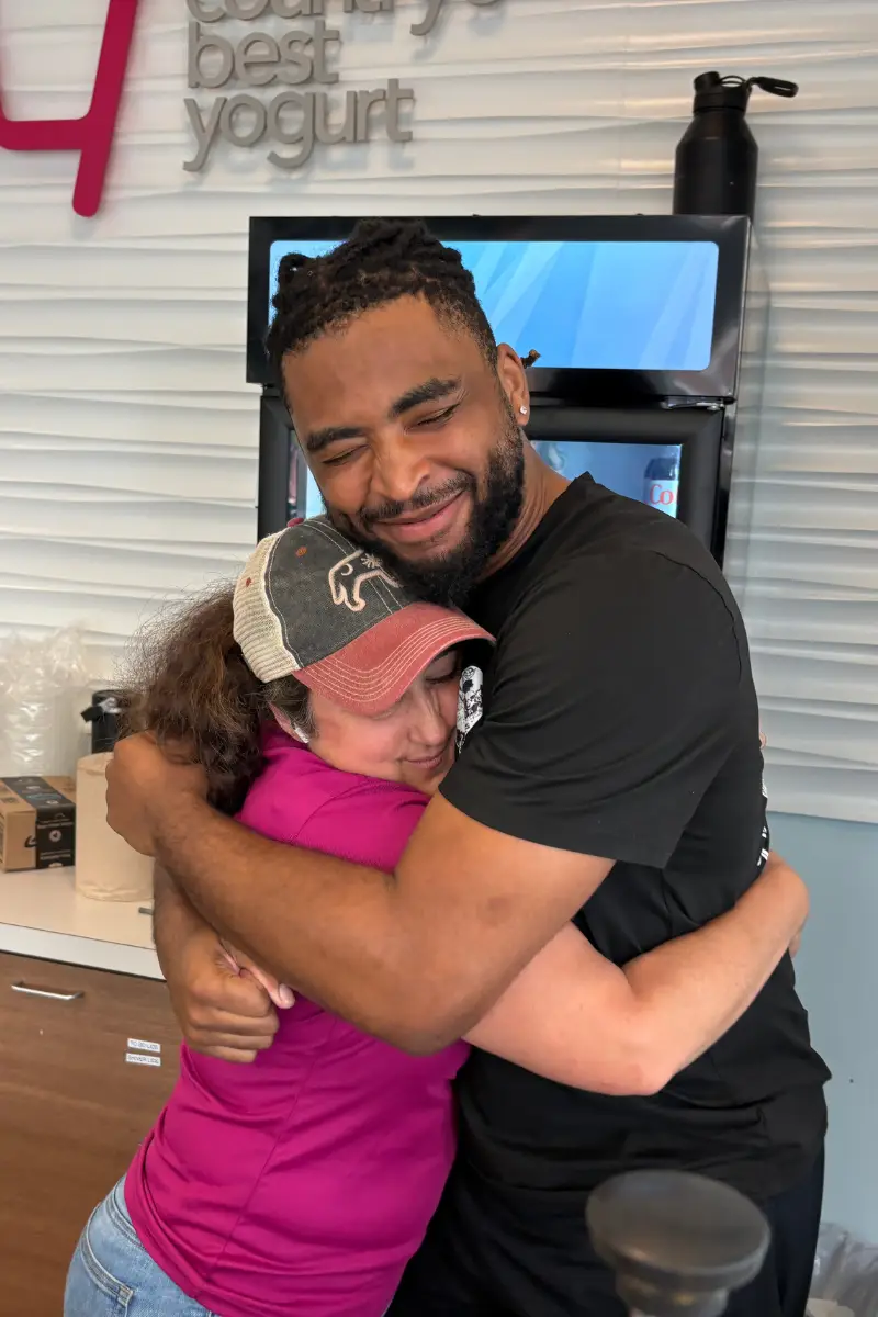 Owner and staff member hugging at TCBY Rosedale