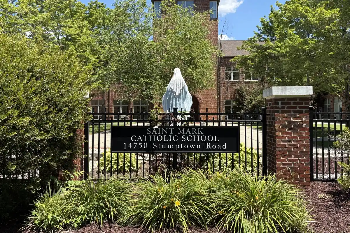 Sign for St Mark Catholic School on the outside of a courtyard of the school