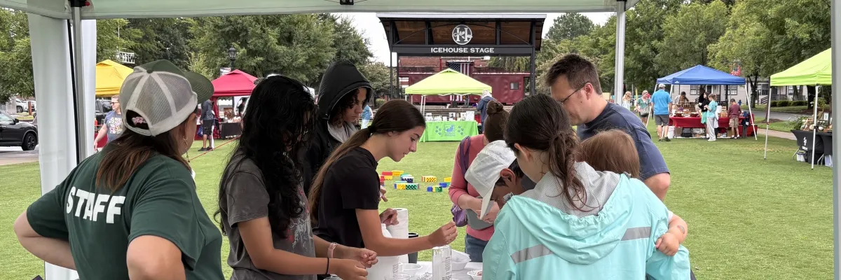 Huntersville Parks & Recreation staff helping kids with a craft activity at the Huntersville Growers' Market
