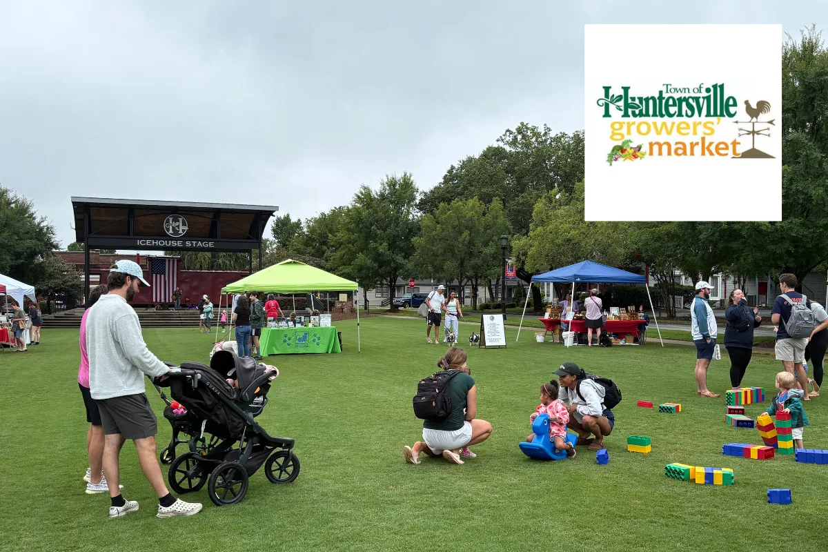 Families browsing vendor tents at the Huntersville Growers' Market, Huntersville's weekly farmers market in Veterans Park