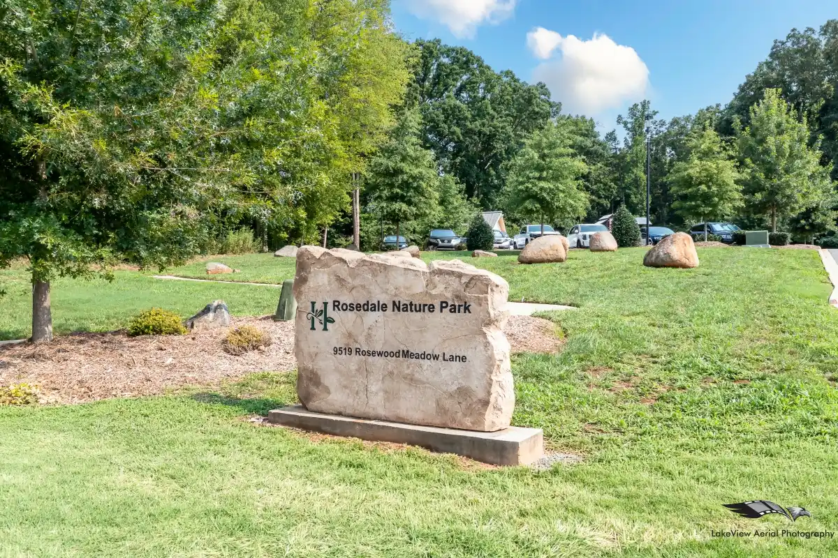 A sign for Rosedale Nature Park on a stone that sits at the entrance to the park
