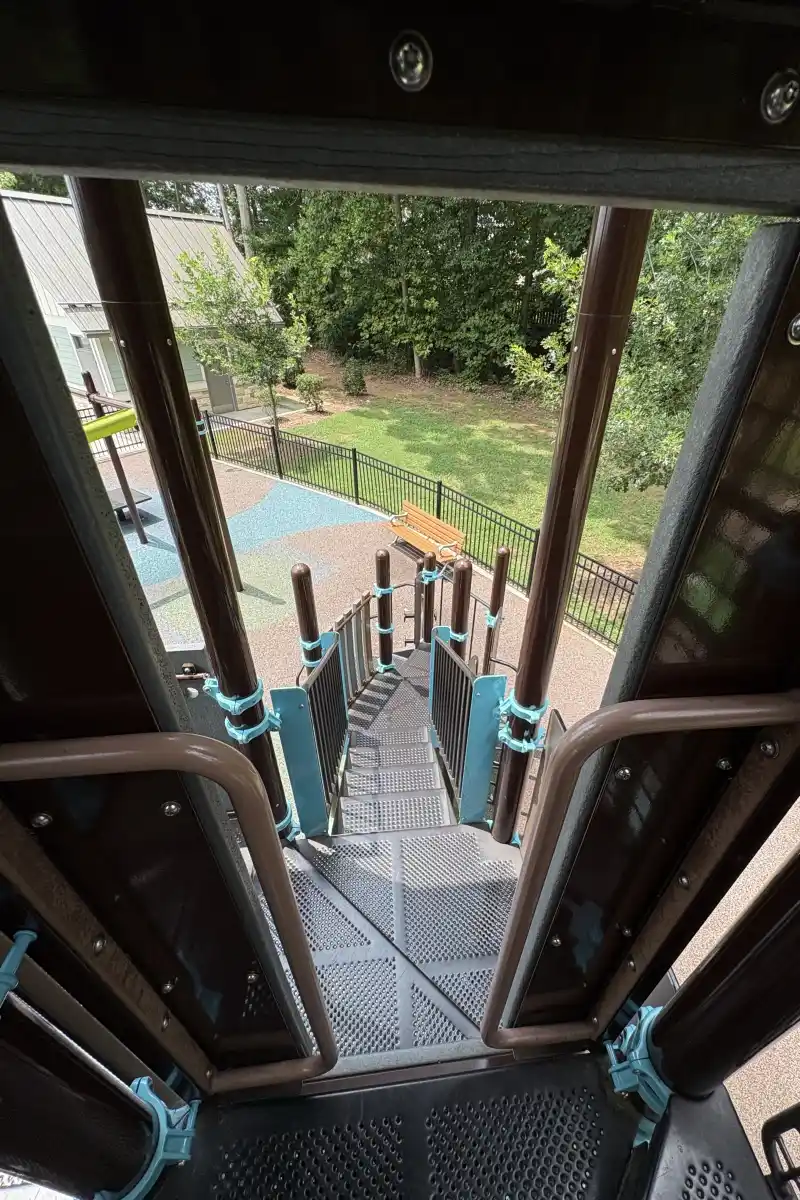 View looking out through the treehouse play structure at Rosedale Nature Park's fenced playground
