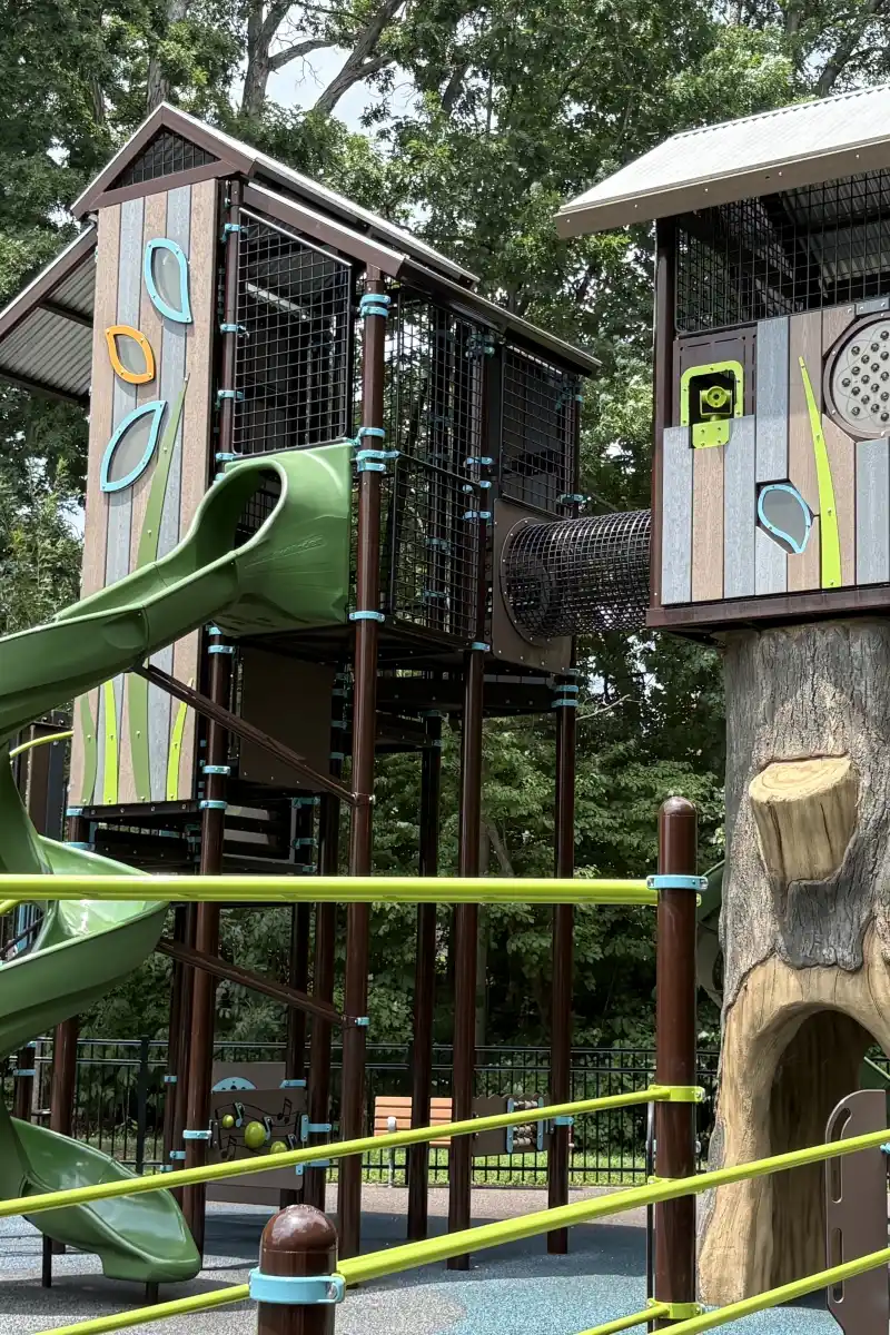 Treehouse-style play towers connected by a tunnel at Rosedale Nature Park's fenced playground