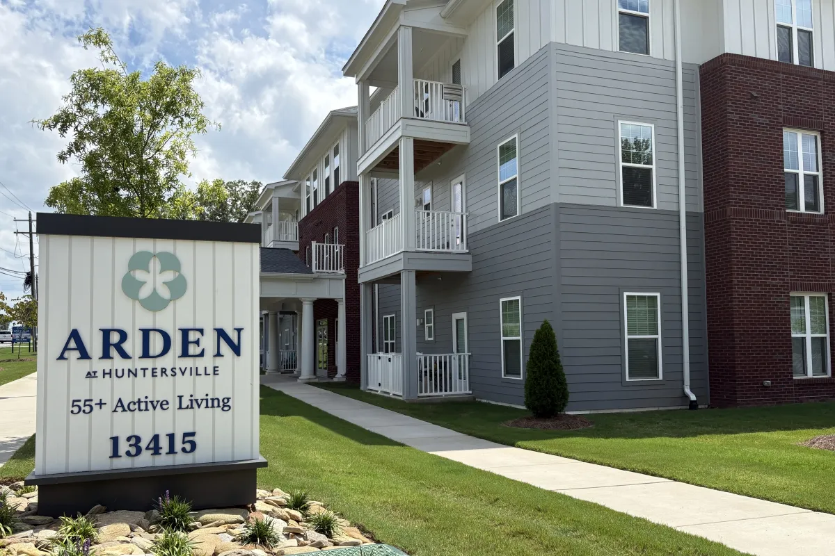 Sign for Arden at Huntersville with apartment building in the background