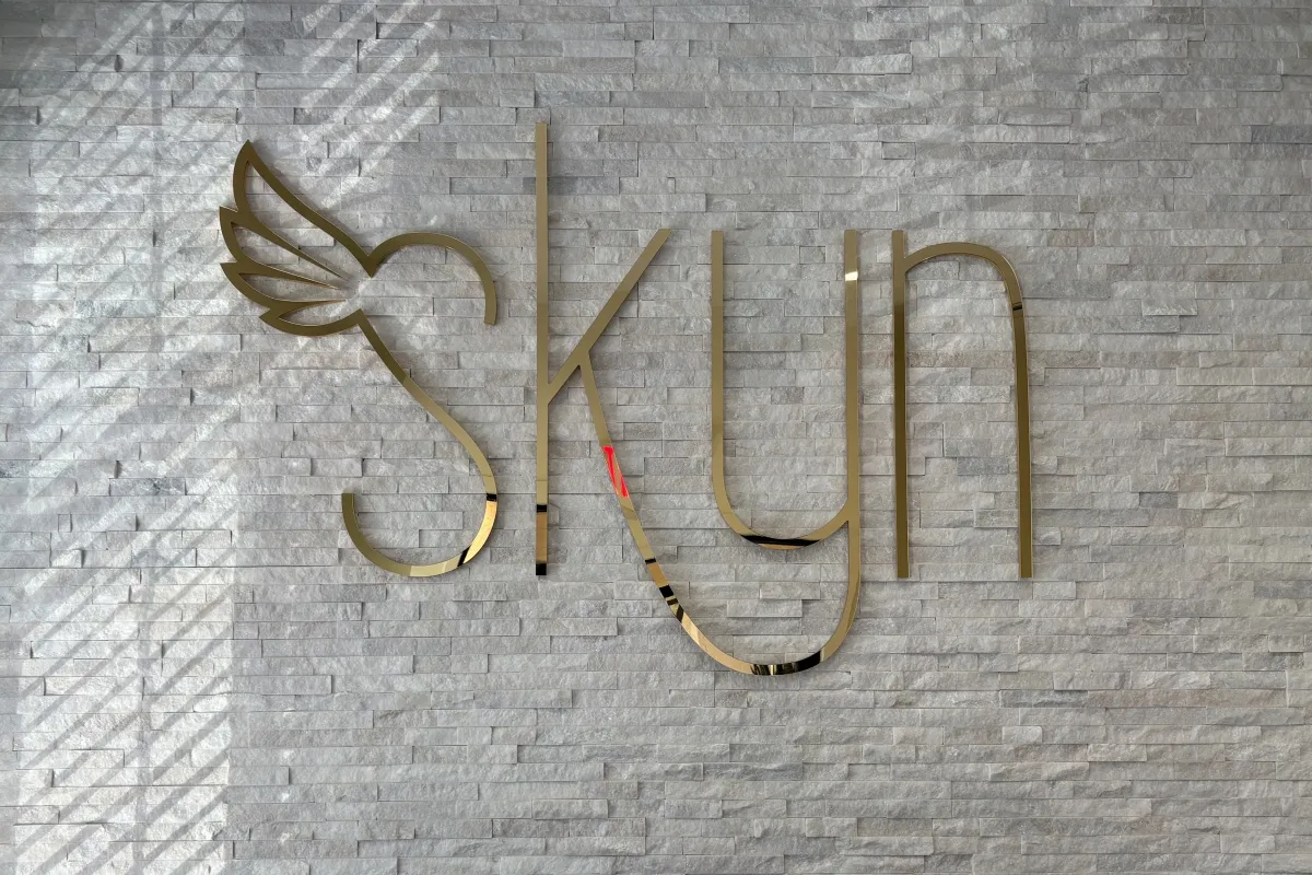 Branded logo sign for SKYN Elegant Aesthetics on an interior office wall