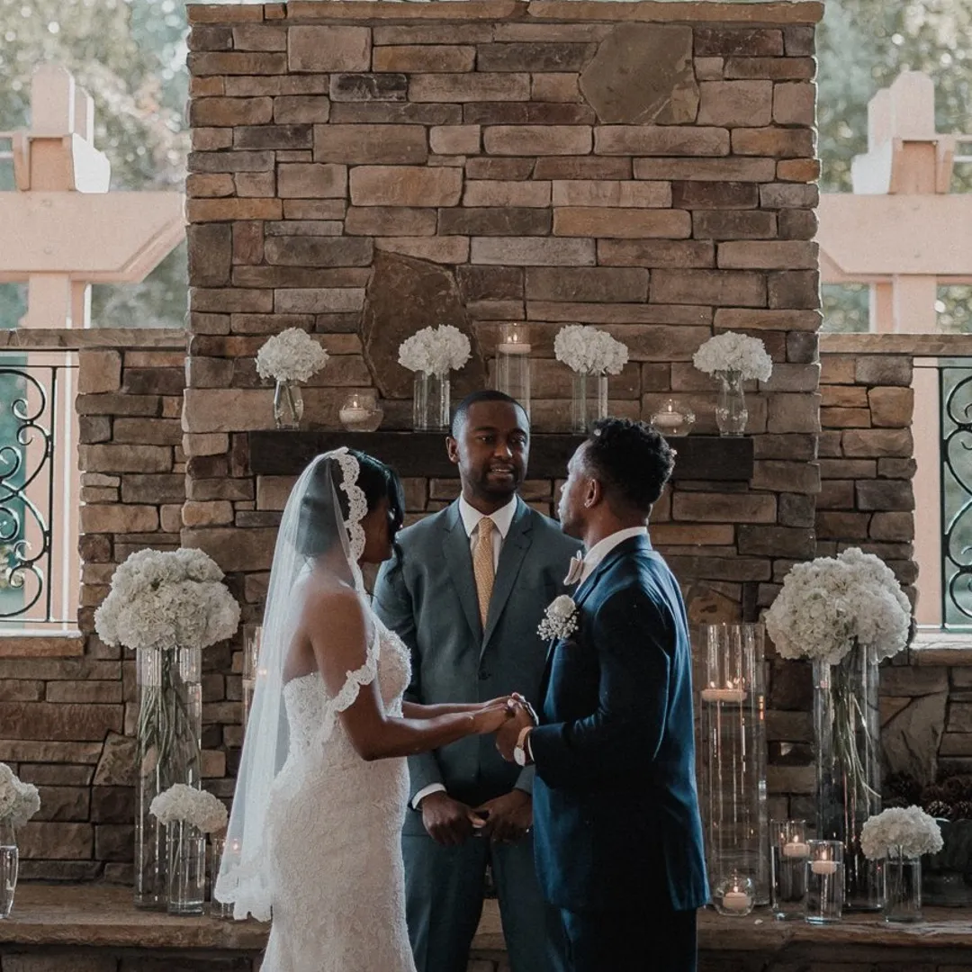 Couple performing wedding vows by fireplace at Magnolia Woods