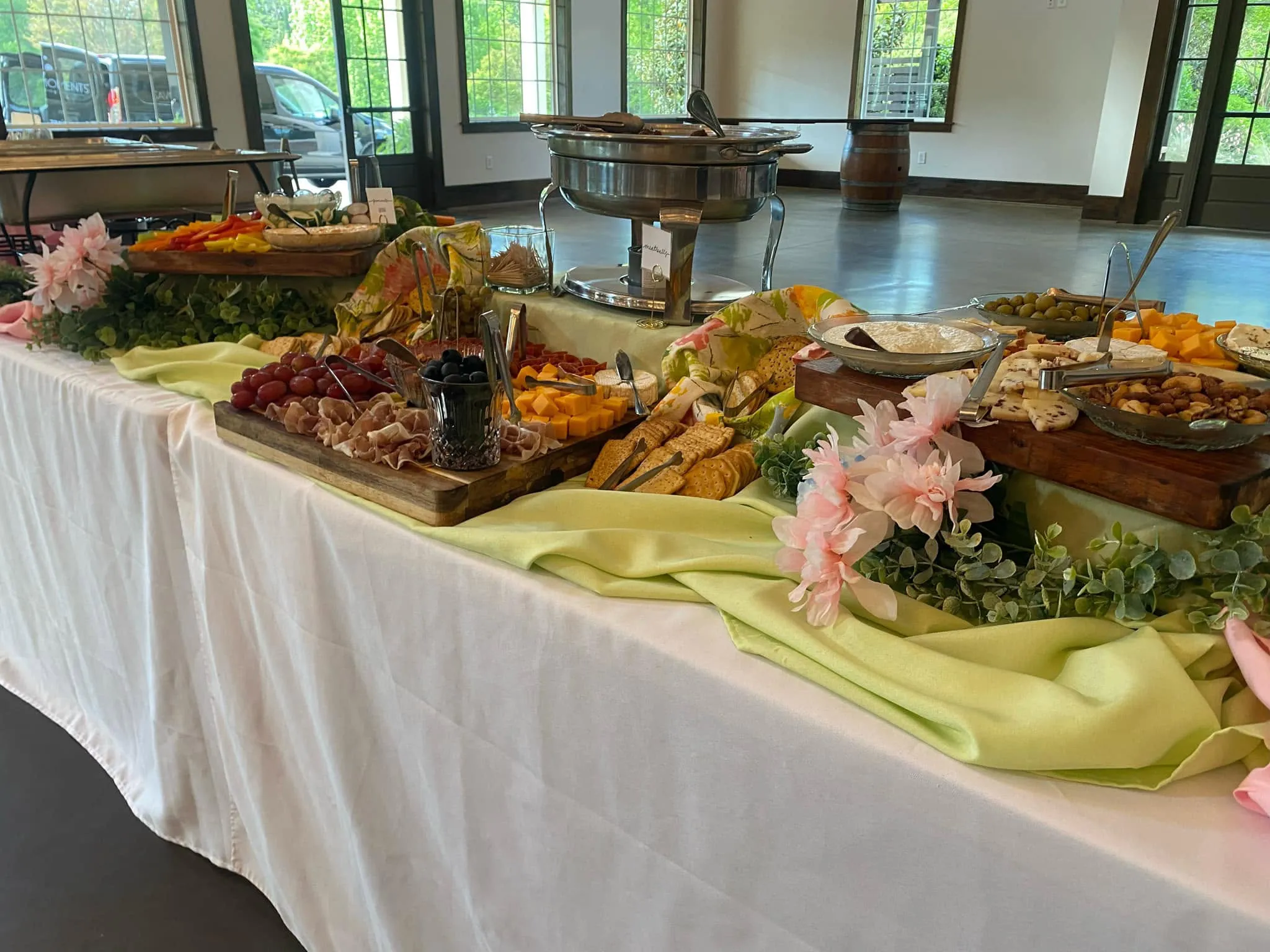 Buffet table set up by Savory Moments Catering with grazing boards and floral accents at Magnolia Woods
