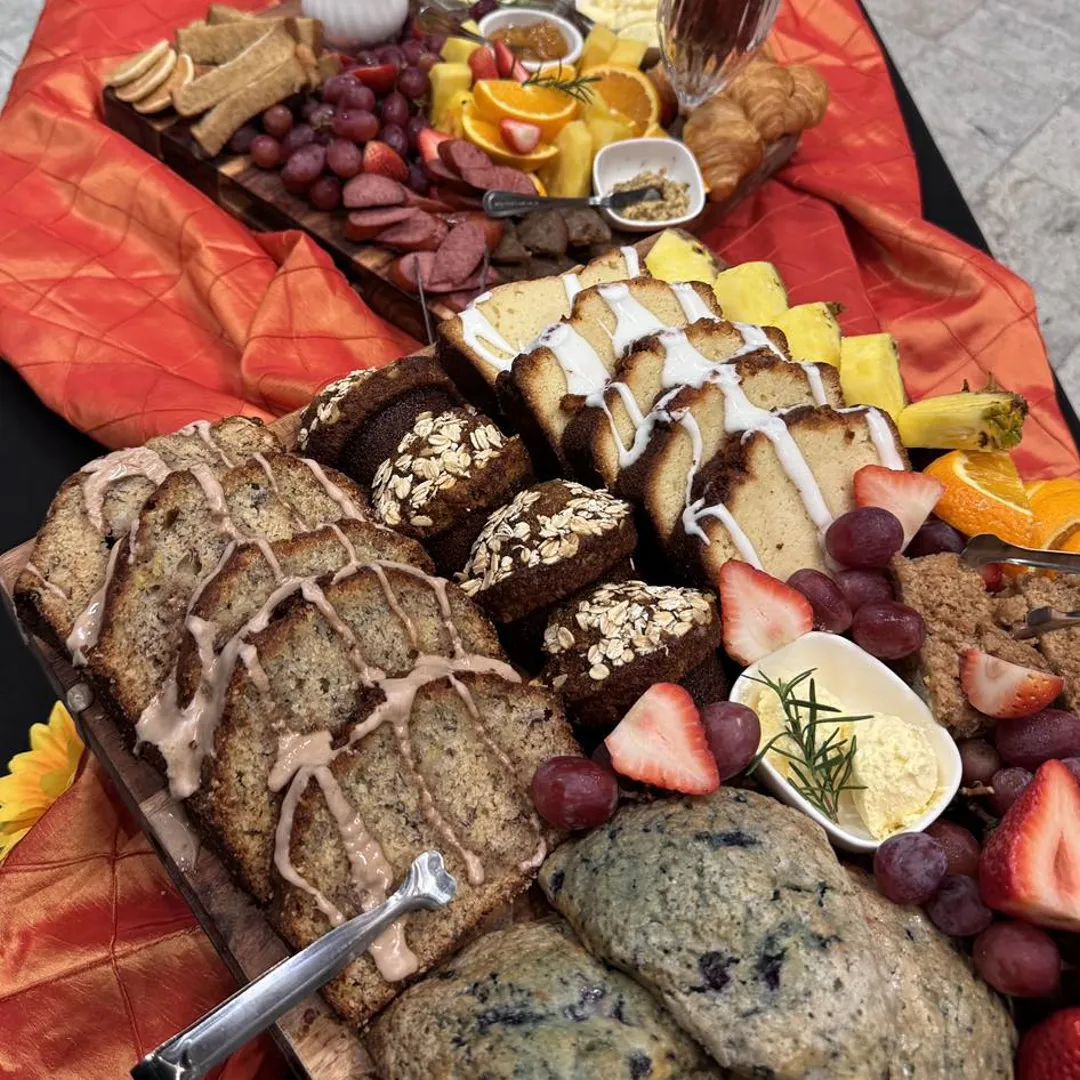 Breakfast board with banana bread, blueberry scones, and fresh fruit from Savory Moments Catering