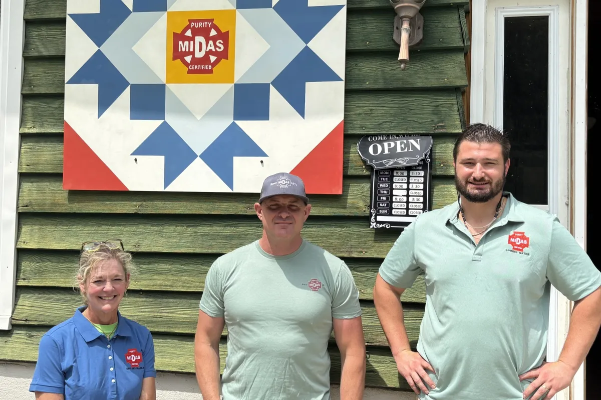 Midas Spring Water team members standing outside the shop