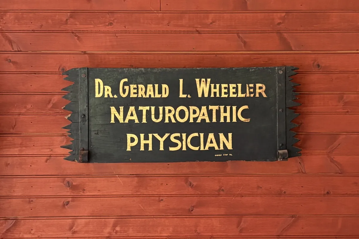Vintage wooden sign reading "Dr. Gerald L. Wheeler, Naturopathic Physician"