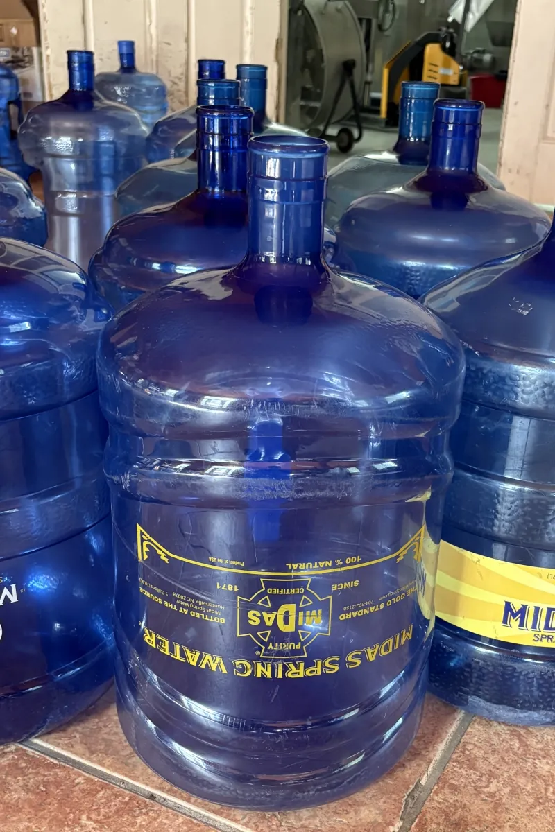 Close-up of a 5-gallon Midas Spring Water jug labeled "The Gold Standard"