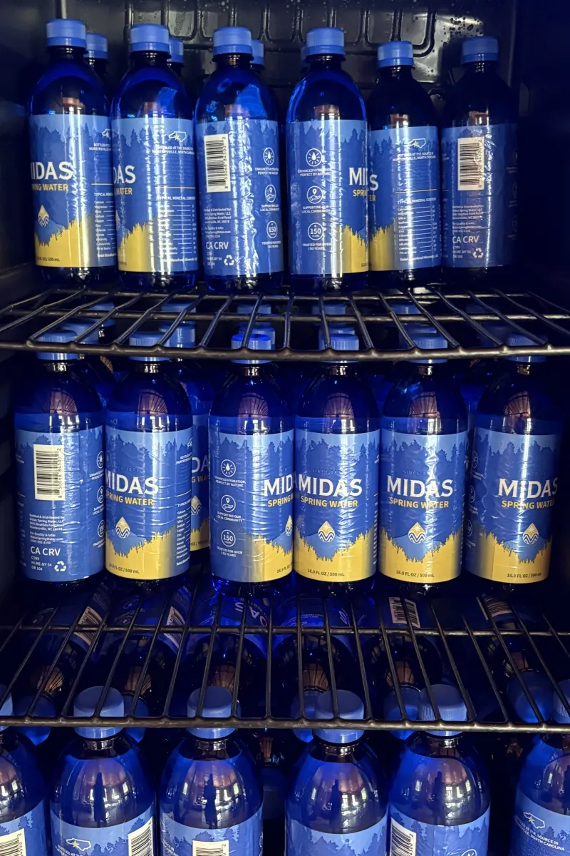 Midas Spring Water bottles stocked on shelving