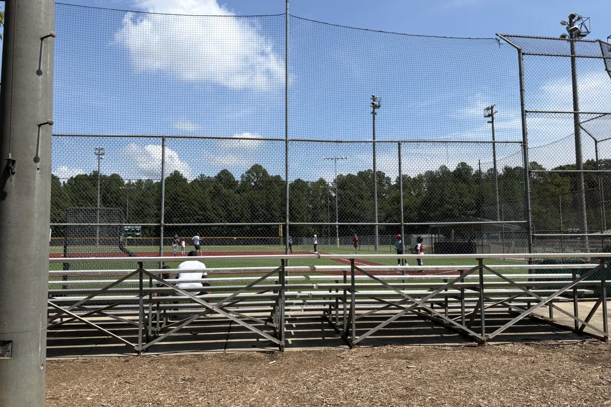 Wide view of a lighted ball field and bleachers at Huntersville Athletic Park
