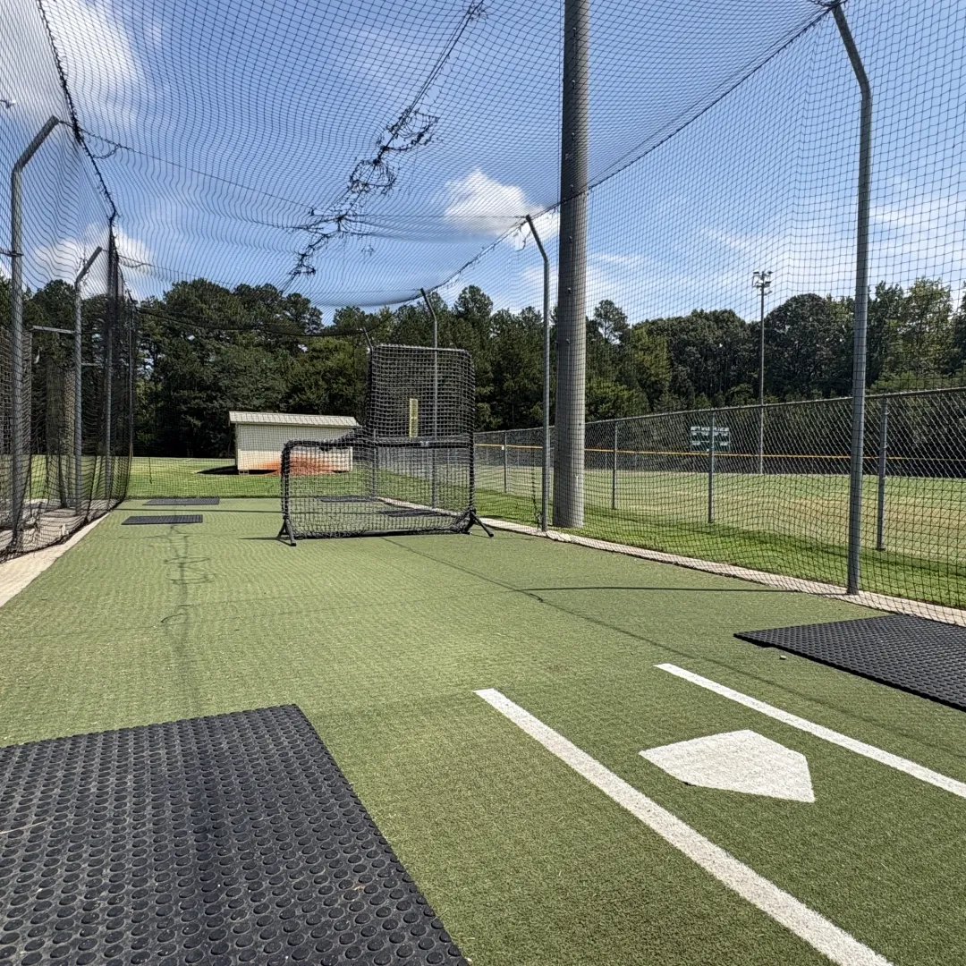 Batting cage at Huntersville Athletic Park with turf flooring, a portable screen, and home plate markings