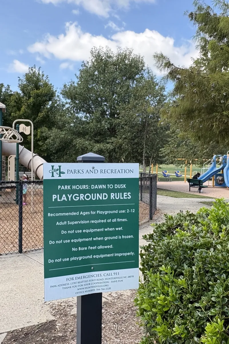 Posted park hours and playground rules sign at Richard Barry Memorial Park