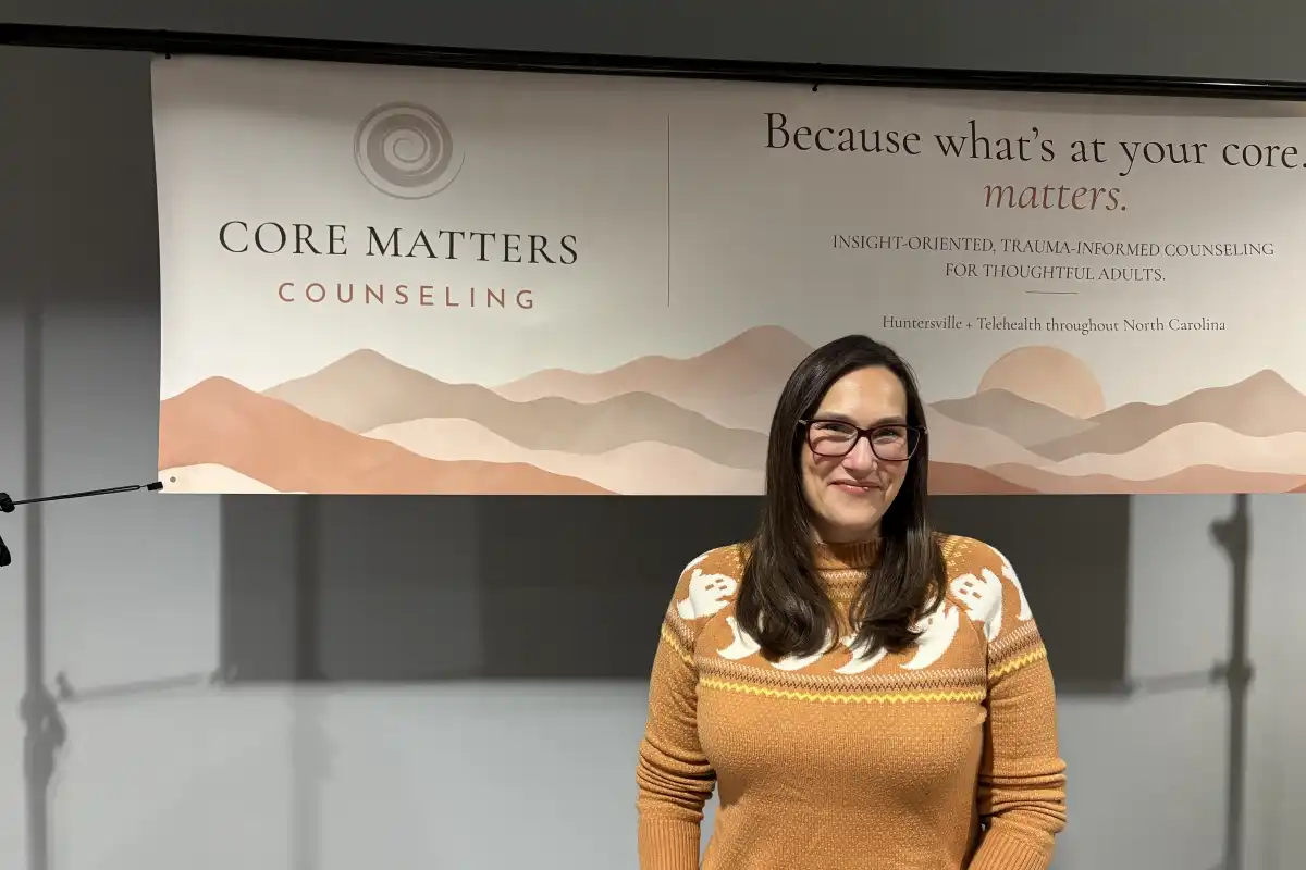 Stephanie Gren of Core Matters Counseling standing in front of a banner